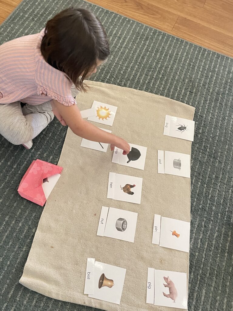 a young student points at a picture as they engage in a learning activity